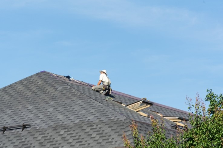A roof repair worker fixing the roof of a house in St. Augustine, FL